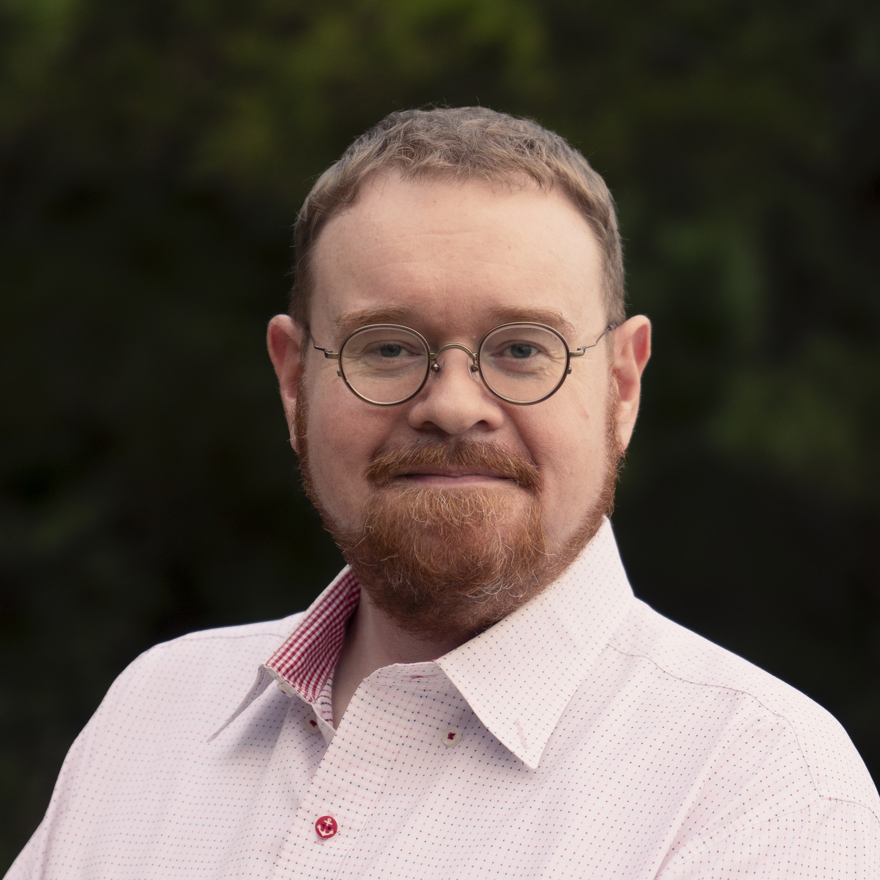 Jim Rion - A white man with a ginger beard and hair, wearing glasses.